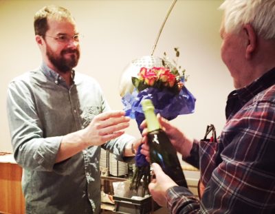 Bildtext: Den avgående kassören Roland Sterner, FSF, fick en stående ovation för sina insatser under årens lopp, och tillträdande kassör Lukas Eisenhauer, FSF, överlämnade en fin vinflaska och ett fång blommor.